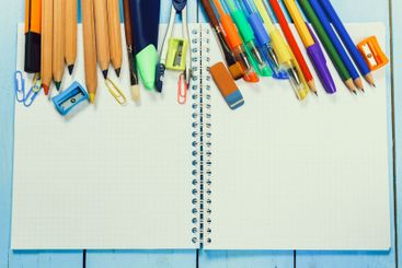 Colorful stationery and a blank notebook on a blue...