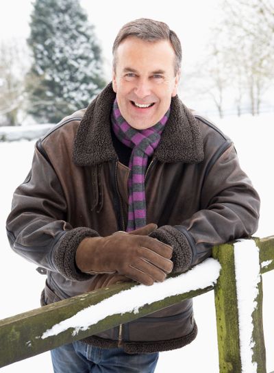 Senior Man Standing Outside In Snowy Landscape