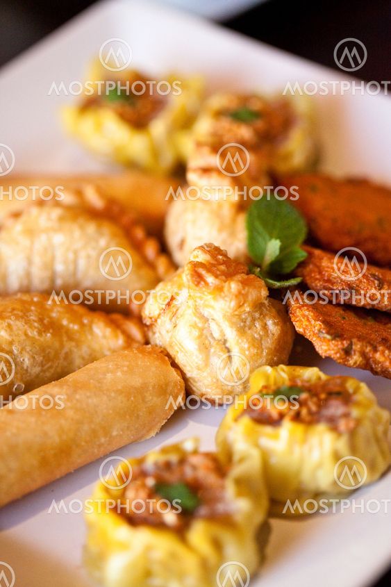 Thai entrees on a plate, spring rolls, curry puff, money bags, fish cake, dim sim.