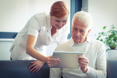 Female nurse showing medical report to senior man on...