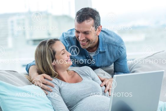 Couple using laptop in living room
