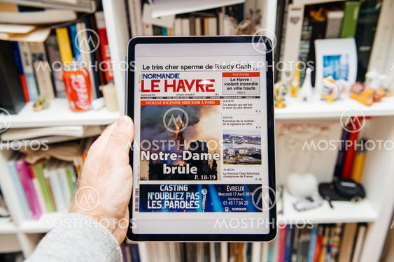 Man reading on iPad Pro about Notre-Dame de Paris fire