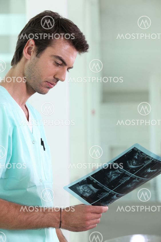 Male nurse examining x-ray image