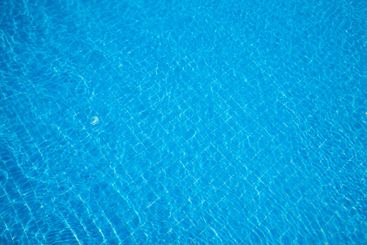 Calm blue water surface shimmering under sunlight...