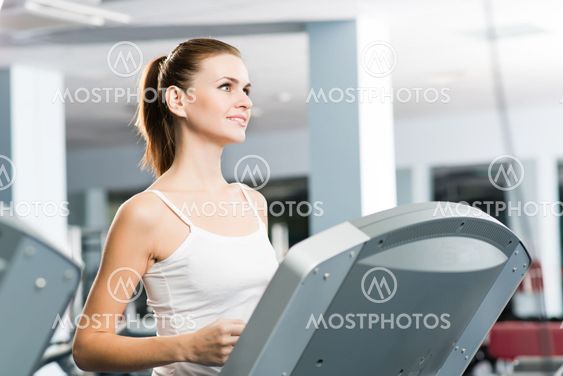 attractive young woman runs on a treadmill