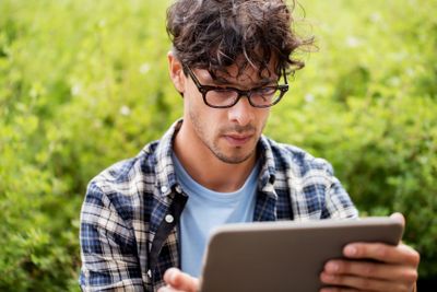 man in glasses with tablet pc computer outdoors