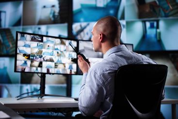 Security System Cctv Monitor Room. Man Using Walkie Talkie