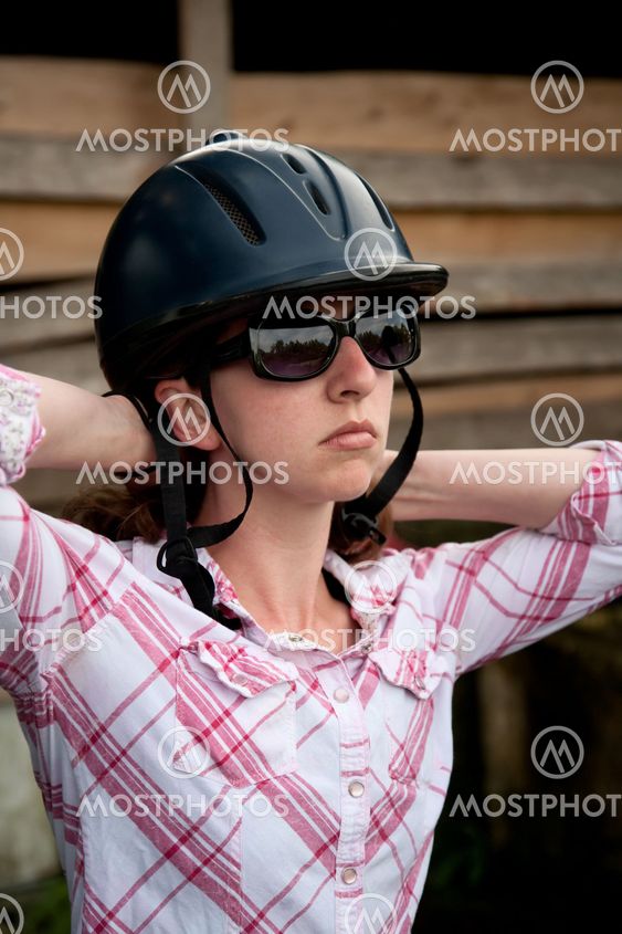 Costa Rican tourist putting on equestrian helmet