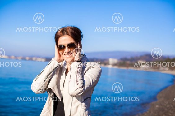 Portrait of Beautiful young woman walking on the beach in winter sunny day alone