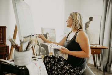 Artist, paint and canvas, happy woman in home studio...