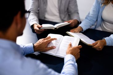 Christian Preacher Reading Holy Bible With Friends in...