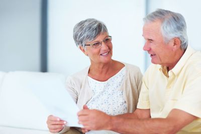 Domestic life. Happy mature woman and man discussing...