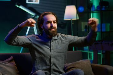 Fan watching live sports event on TV, chanting for team,...