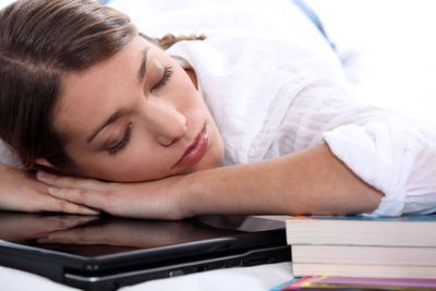 young woman sleeping on her computer