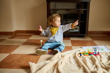 Young Child Playing Indoors with Wooden Toys on a...