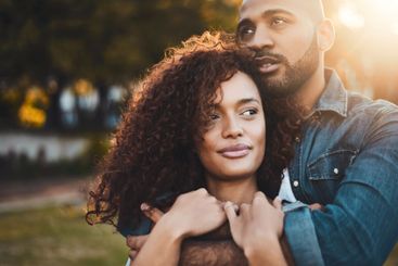 Love, couple and hug at park together for sunset date,...