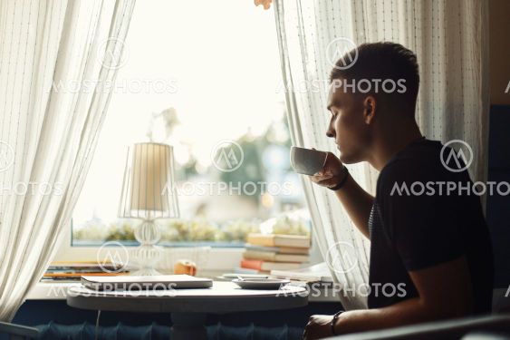 Handsome man drinking coffee in a restaurant.