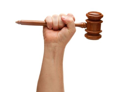 Man Holding Wooden Gavel in Fist on White