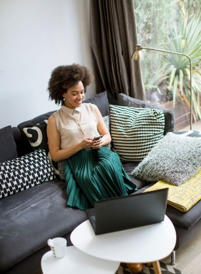 Attractive young woman working on laptop and using...
