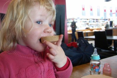 Flicka äter smörgås