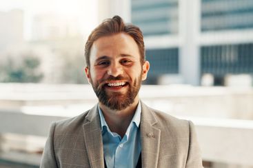 Business, portrait and smile of happy man in city for...