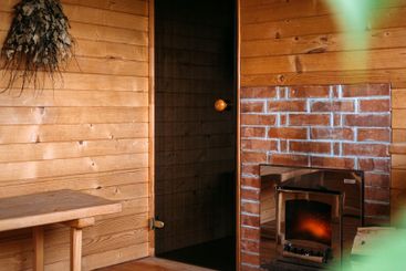 Cozy home sauna with wooden interior, brick fireplace,...