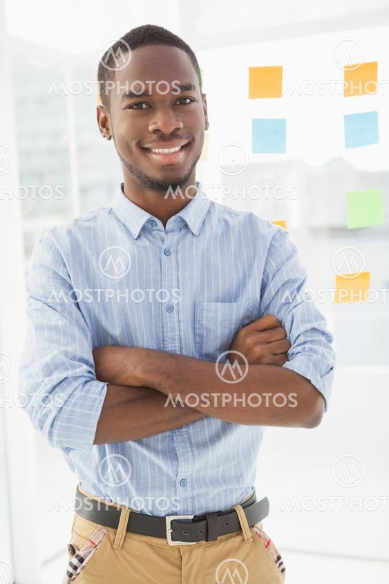 Smiling businessman standing with arms crossed
