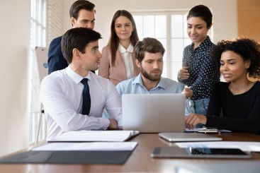 Staff using laptop working together on joint task