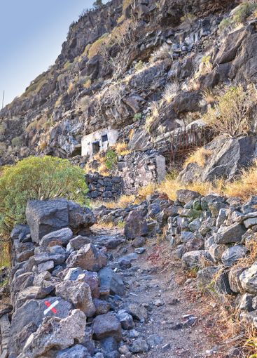 Mountain, rocks and trail with path on small island with...