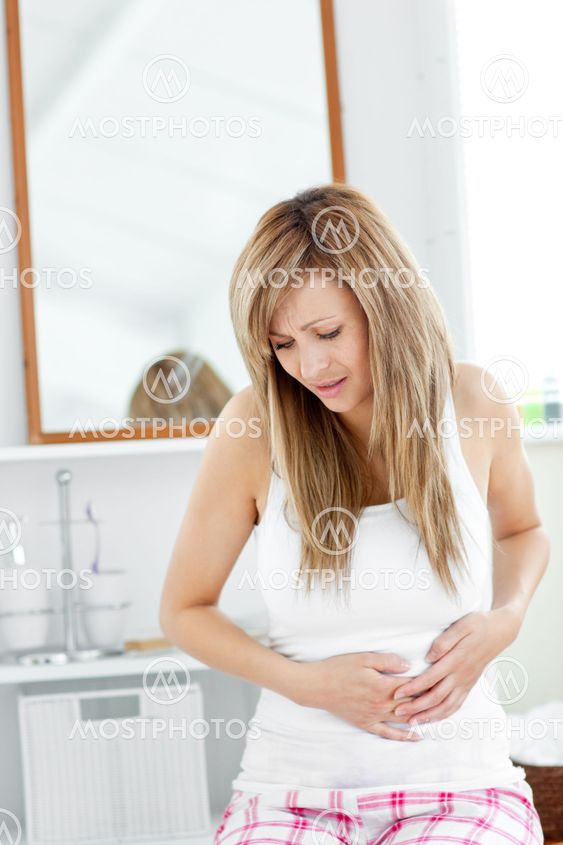 Suffering woman having a stomachache in her bathroom