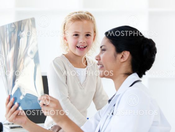 Caring female doctor showing an x-ray to a little girl