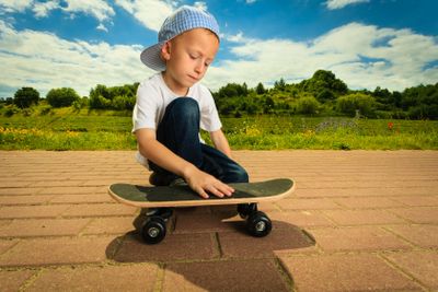 Skater boy child with his skateboard. Outdoor activity.