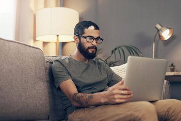 Remote work, laptop and man on sofa for online project,...