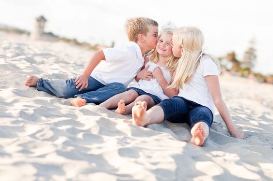 Adorable Sibling Children Kissing the Youngest