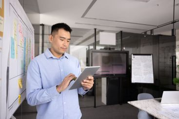 Focused young Asian manager man using modern technology...