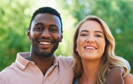 Joyful Young Couple Smiling Together in Bright Green Park...