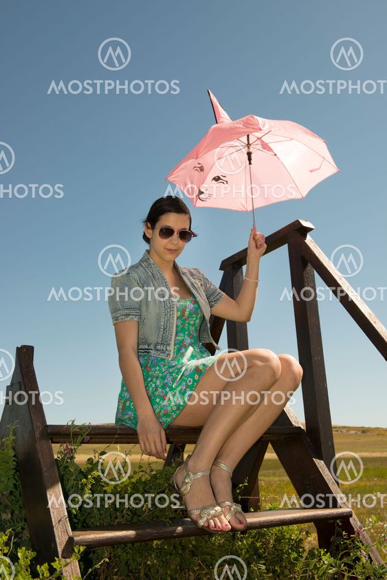 Beautiful adult smelling flowers on sunny field enjoying herself