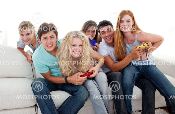 Teenagers playing video games at home