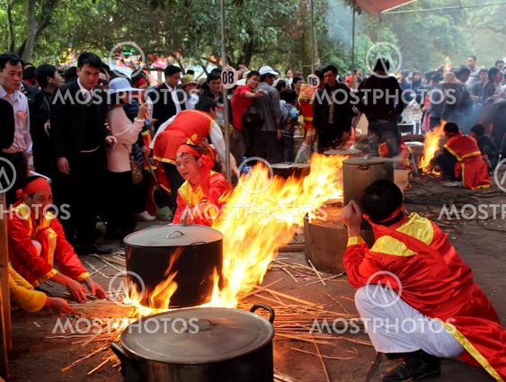 People in traditional costume exam to make round sticky...
