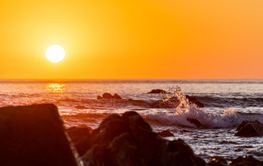 close up shot of waves hitting a stone at the beach at...