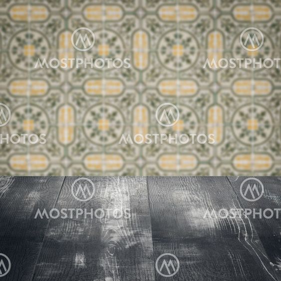Wood table top and blur vintage ceramic tile pattern wall