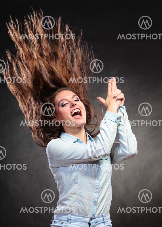 Woman having fun pretending hand finger is a gun.