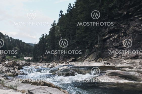 stormy crystal clear river in the rocky Carpathian...