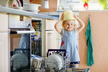 Little adorable cute toddler girl helping to unload...