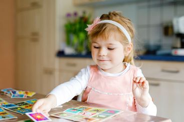 Adorable cute toddler girl playing picture card game....