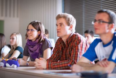 College students sitting in a classroom during class...
