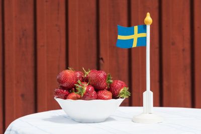 Bowl with fresh strawberries and a swedish flag