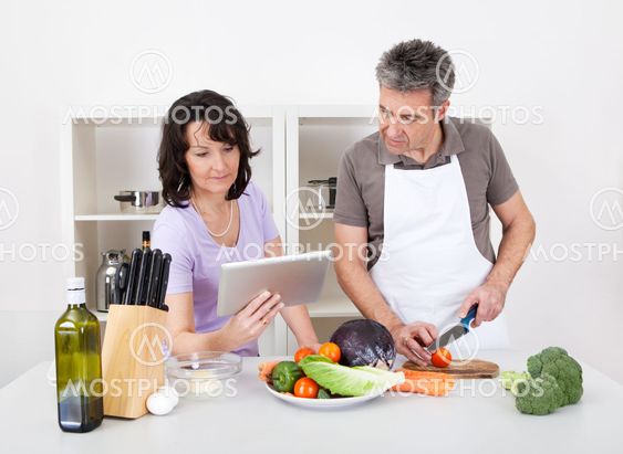 Senior couple cooking lunch at home