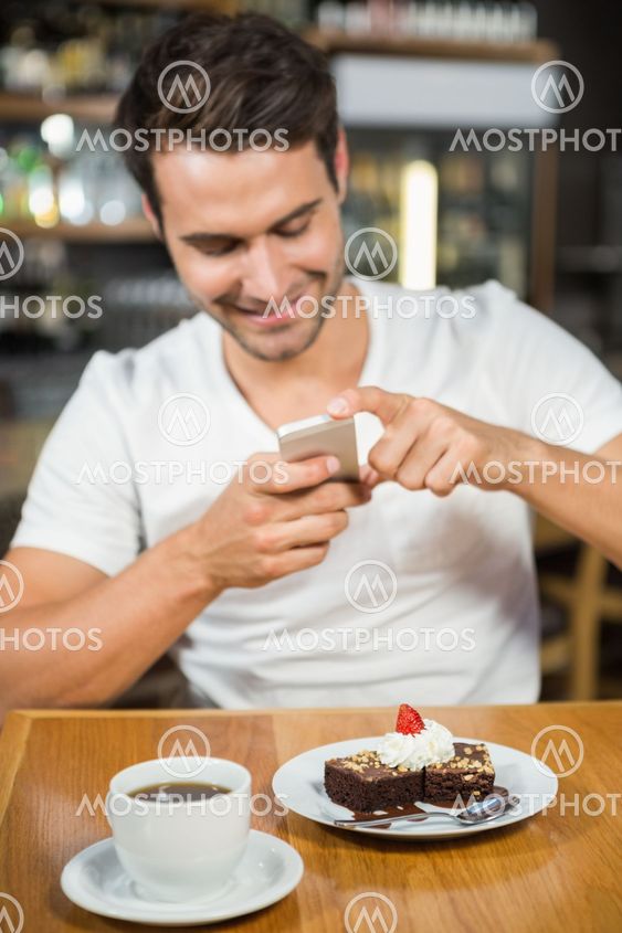Handsome man taking a picture of his food