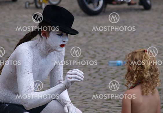 Street actor and young girl (tourist) on Old Market Place in Kazimierz Dolny, Poland